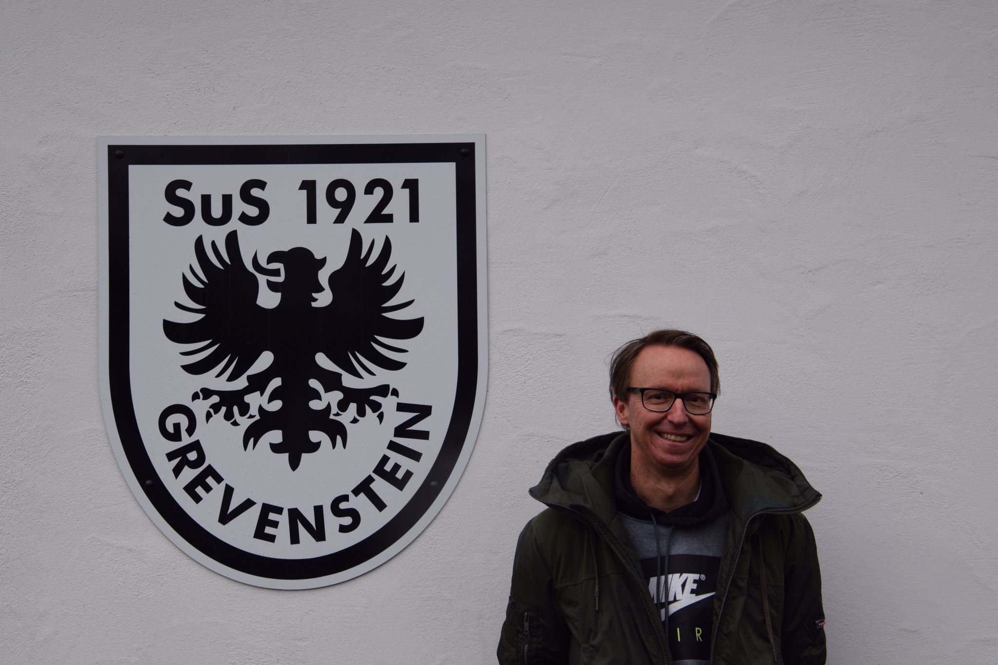Ingo Jung vor dem SuS Grevenstein-Wappen am Sportheim