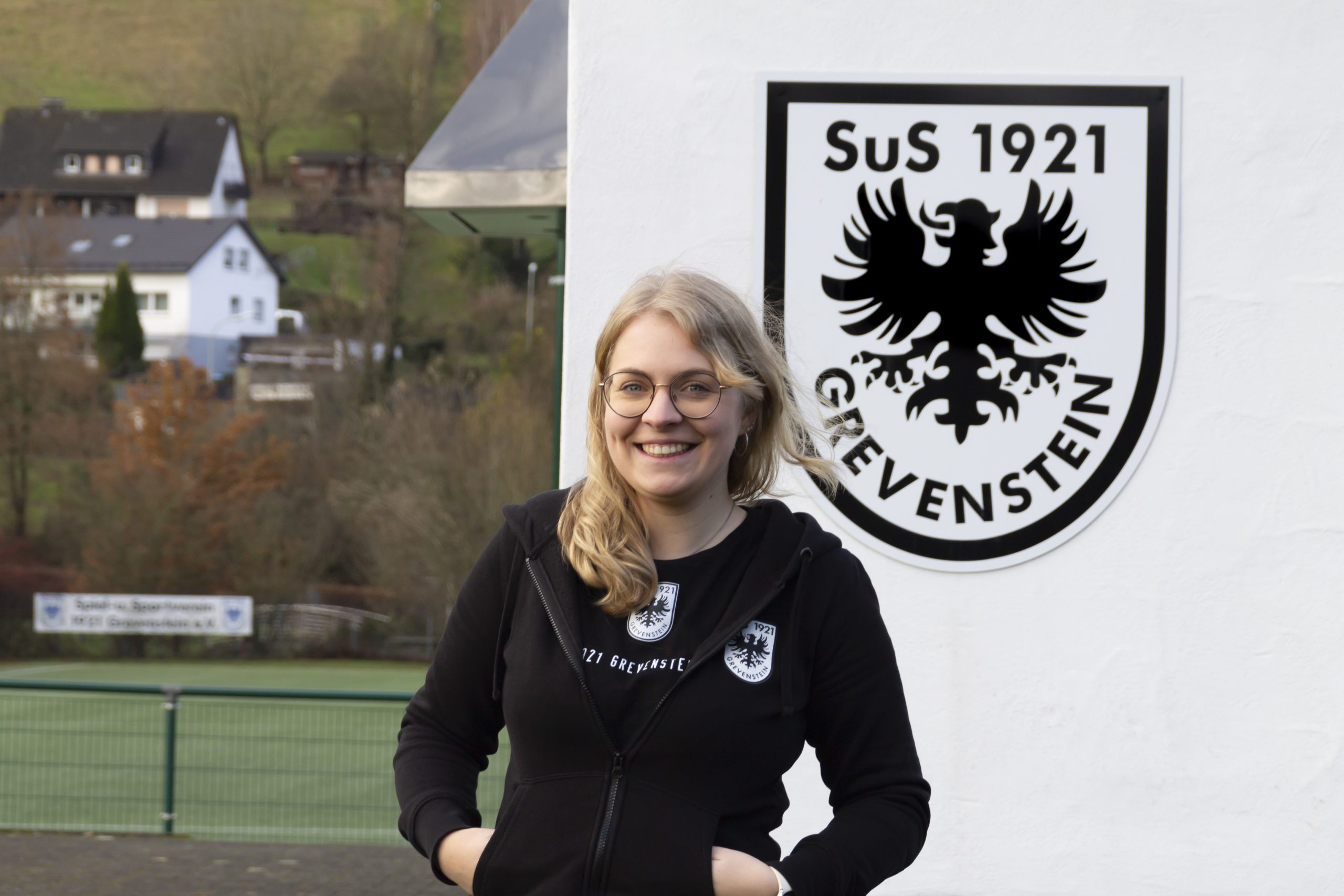 Portrait von Anneke Thüsing vor dem SuS Grevenstein Wappen