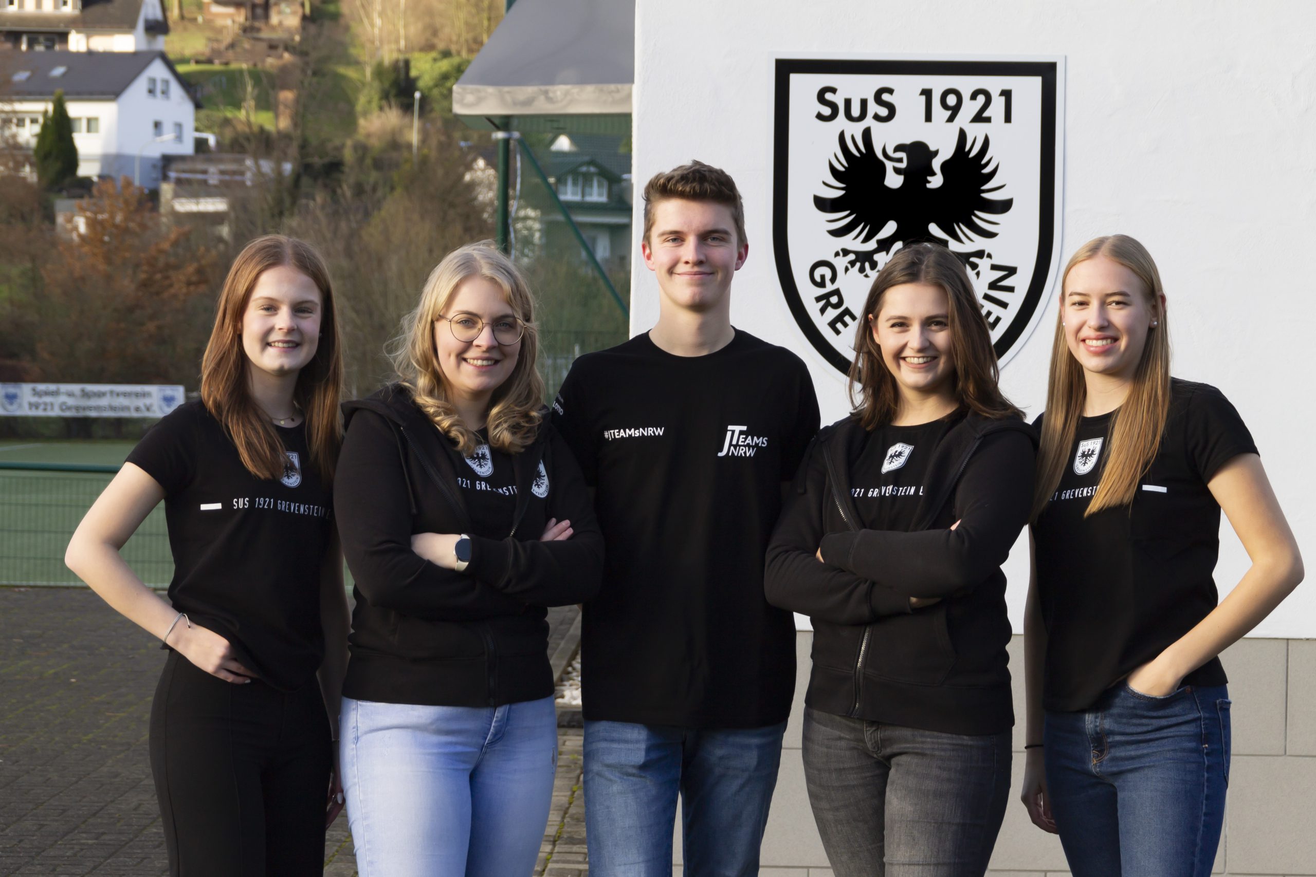 Gruppenbild des J-Teams, von links nach rechts Von links nach rechts: Paula Müller, Anneke Thüsing, Luca Jung, Maja Müller, Thea Einheuser vor dem Wappen des SuS Grevenstein am Sportlerheim