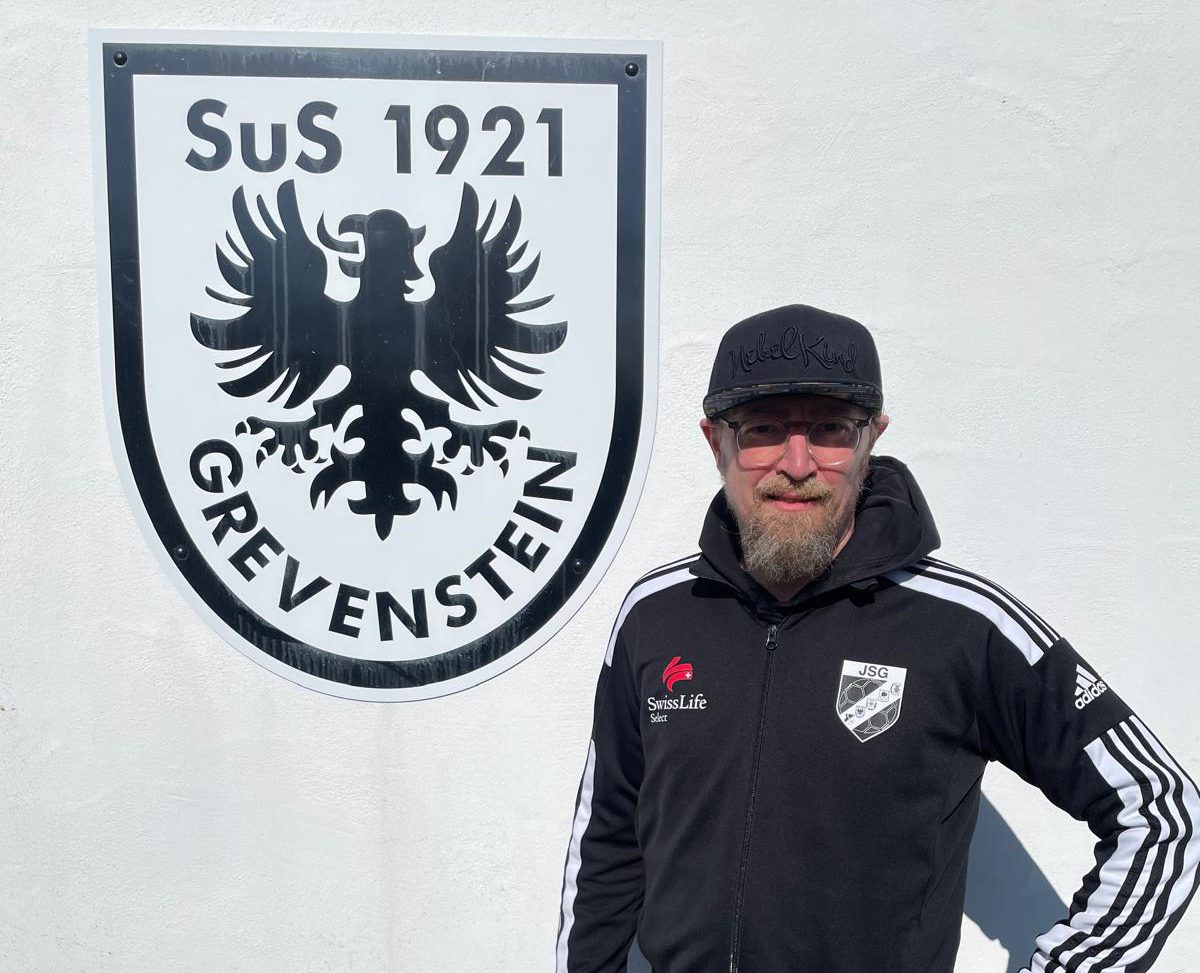 Axel Müller vor dem SuS-Wappen am Sportlerheim